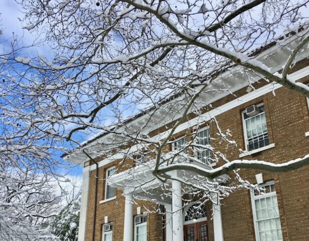 Shows the side entrance of Blaney hall, snow on the ground and on nearby tree limbs